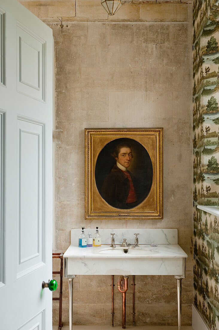 Waschtisch und Porträt in einem Raum mit historischem Charakter