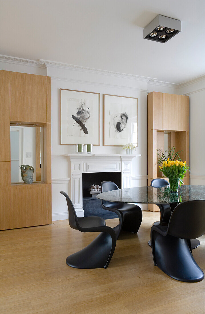 Dining room with black chairs, yellow flowers and fireplace