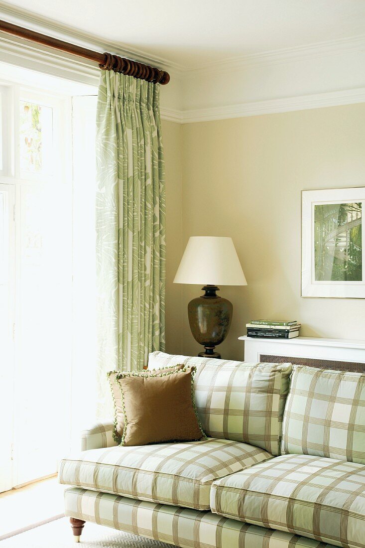 Light, natural colours in traditional living room with subtle, checked fabric sofa cover