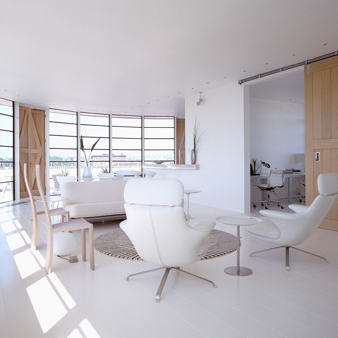 Open-plan living room with white furniture and white flooring