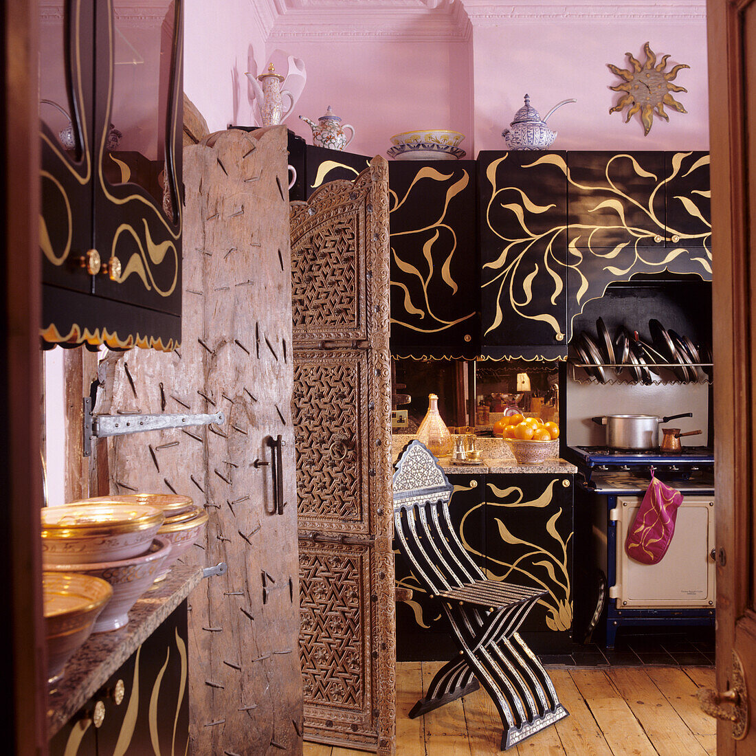 Kitchen with oriental accents, black fronts and golden ornaments