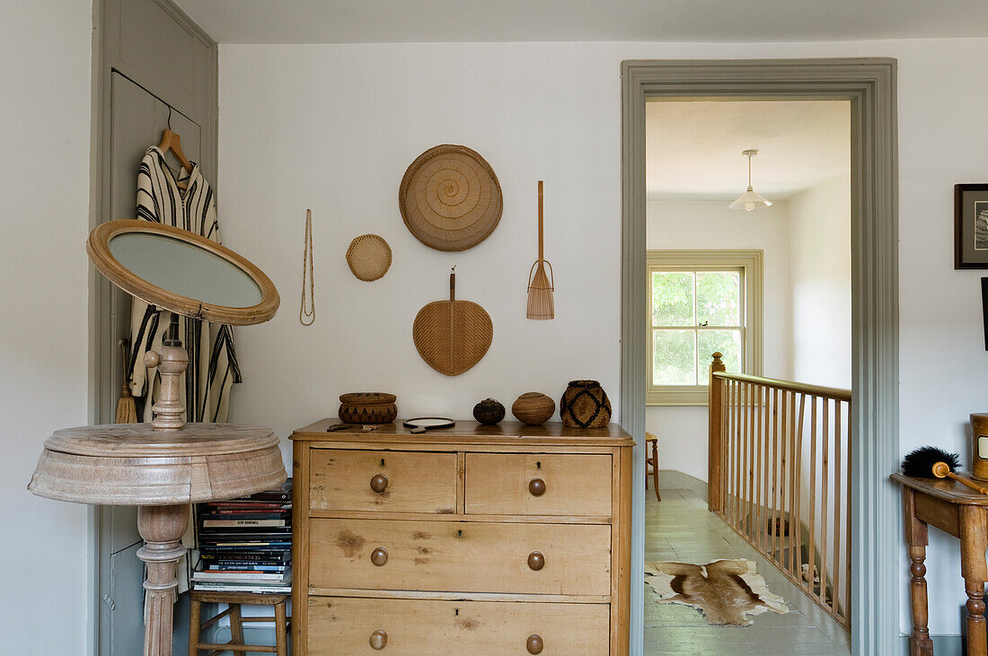 Room with wooden chest of drawers and antique mirror stand, view of staircase