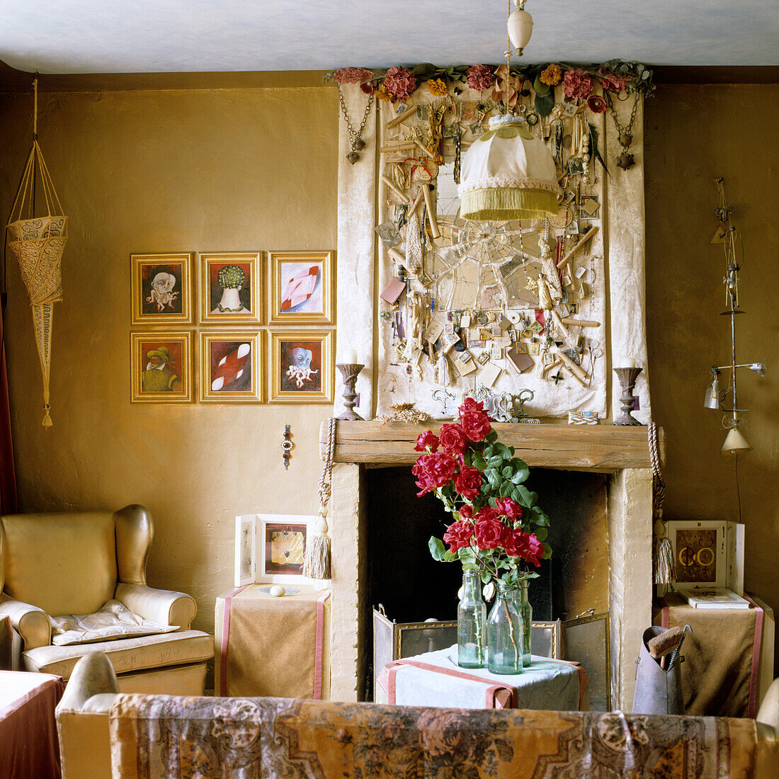 Living room with opulent fireplace, floral arrangement and wall decorations in gold tones