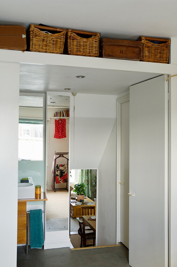 View of washbasin and shelf above door with baskets