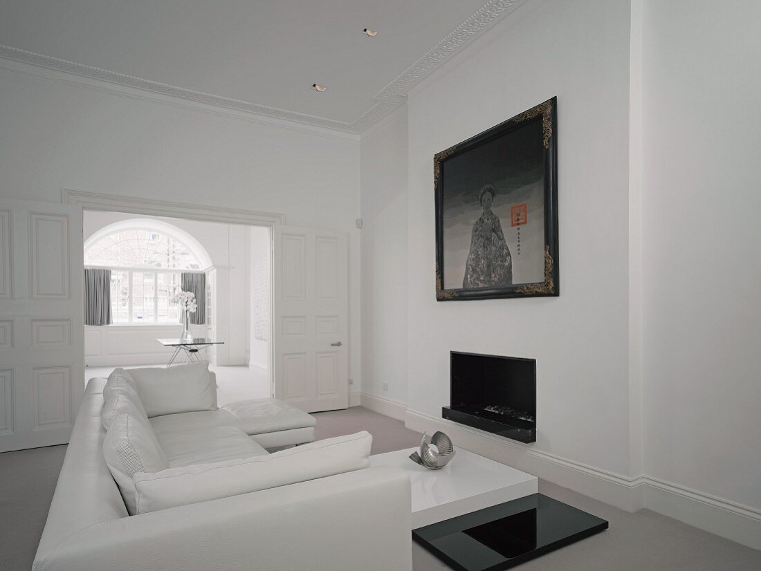 Wohnzimmer in Weiß mit Sofa, Couchtisch & Kamin