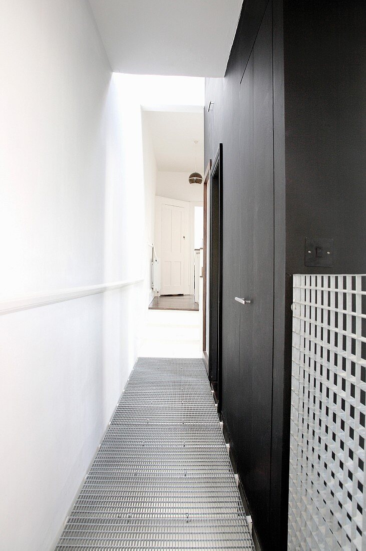Corridor with black walls & wire mesh floor