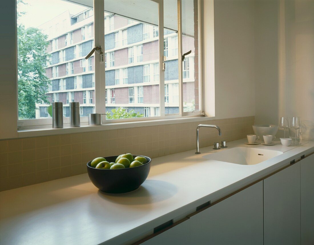 White kitchen unit with window & view of apartment building front