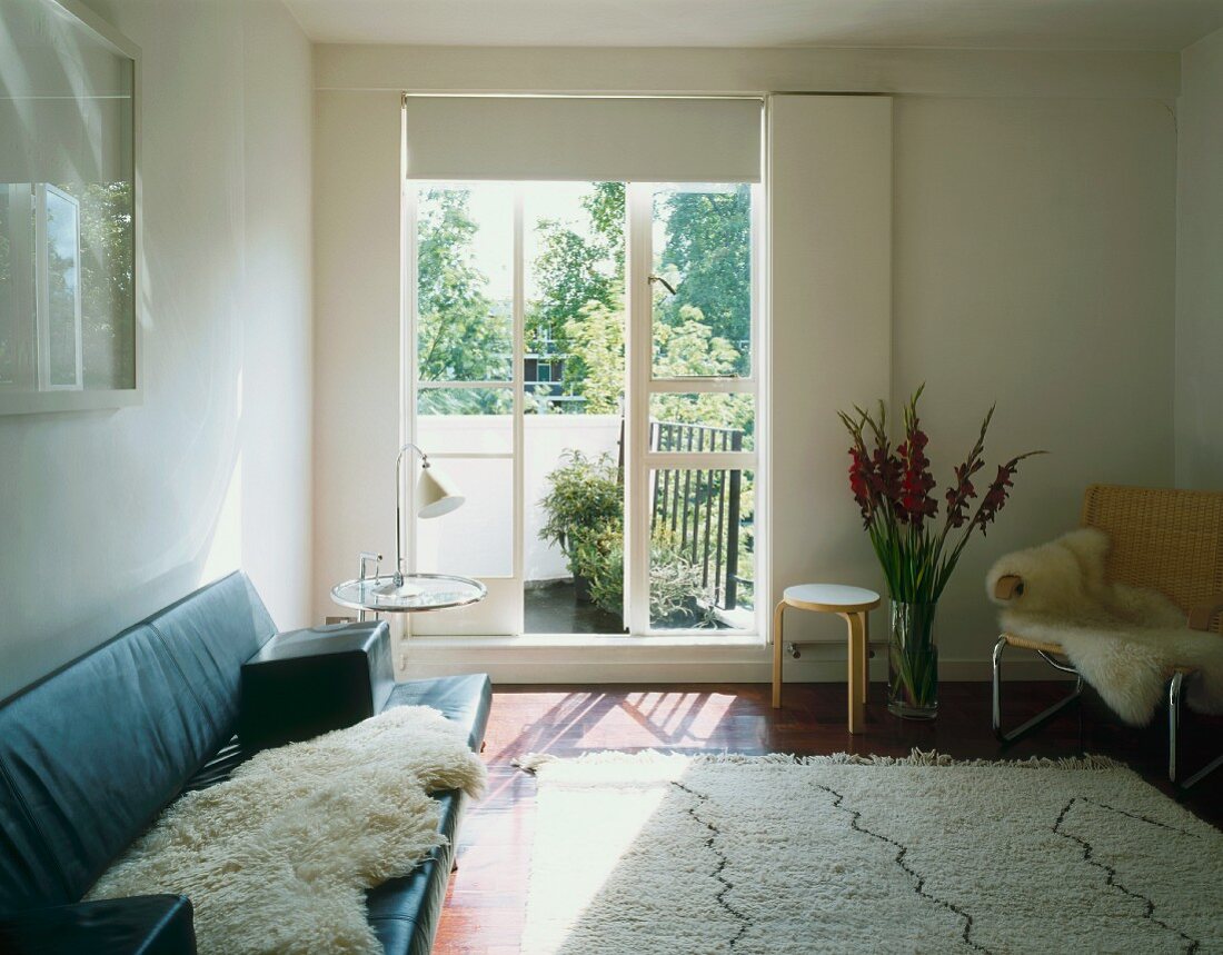 Living room with sofa, chair, rug & balcony