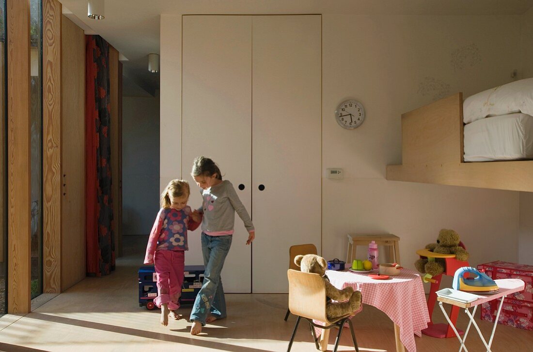 Zwei Kinder spielen in Kinderzimmer mit Spielecke & Hochbett