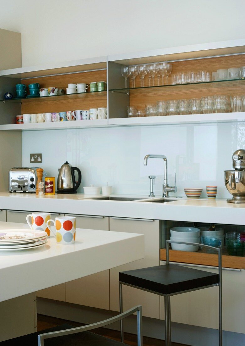 Moderne Küche mit Geschirrregal und Küchentresen mit Barstuhl