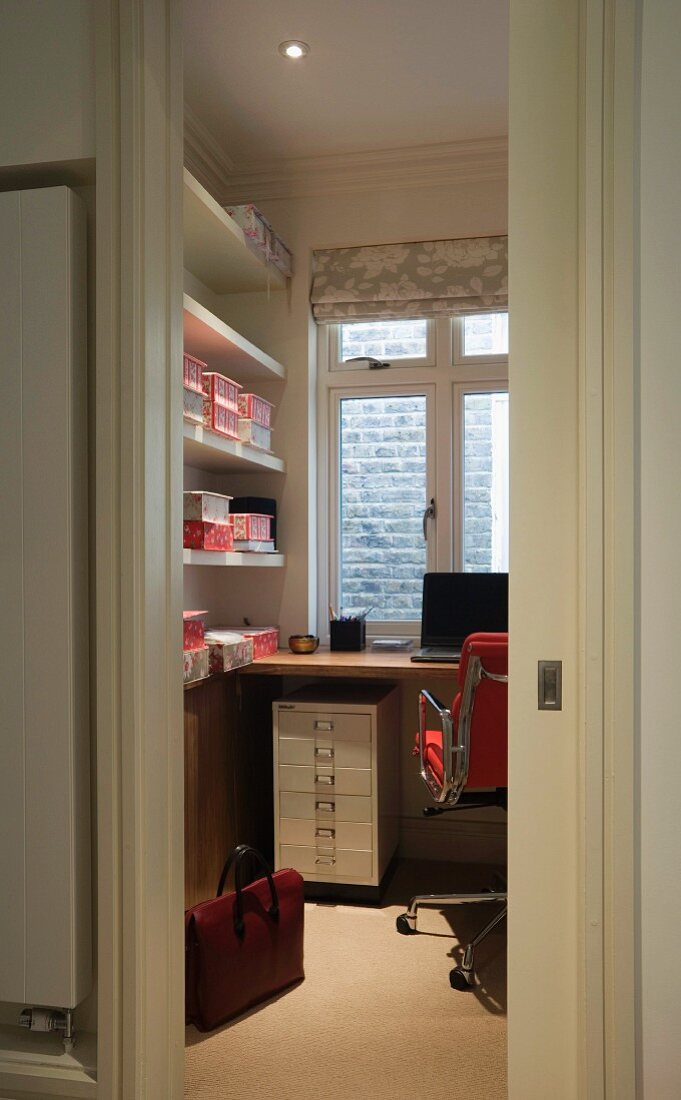An office with a wall of shelves and a metal drawer unit