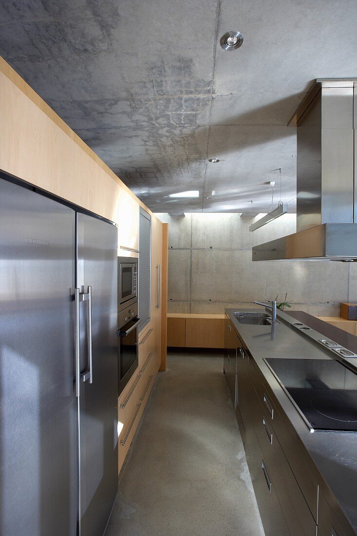Designerküche mit Edelstahloberflächen im Wohnhaus aus Beton