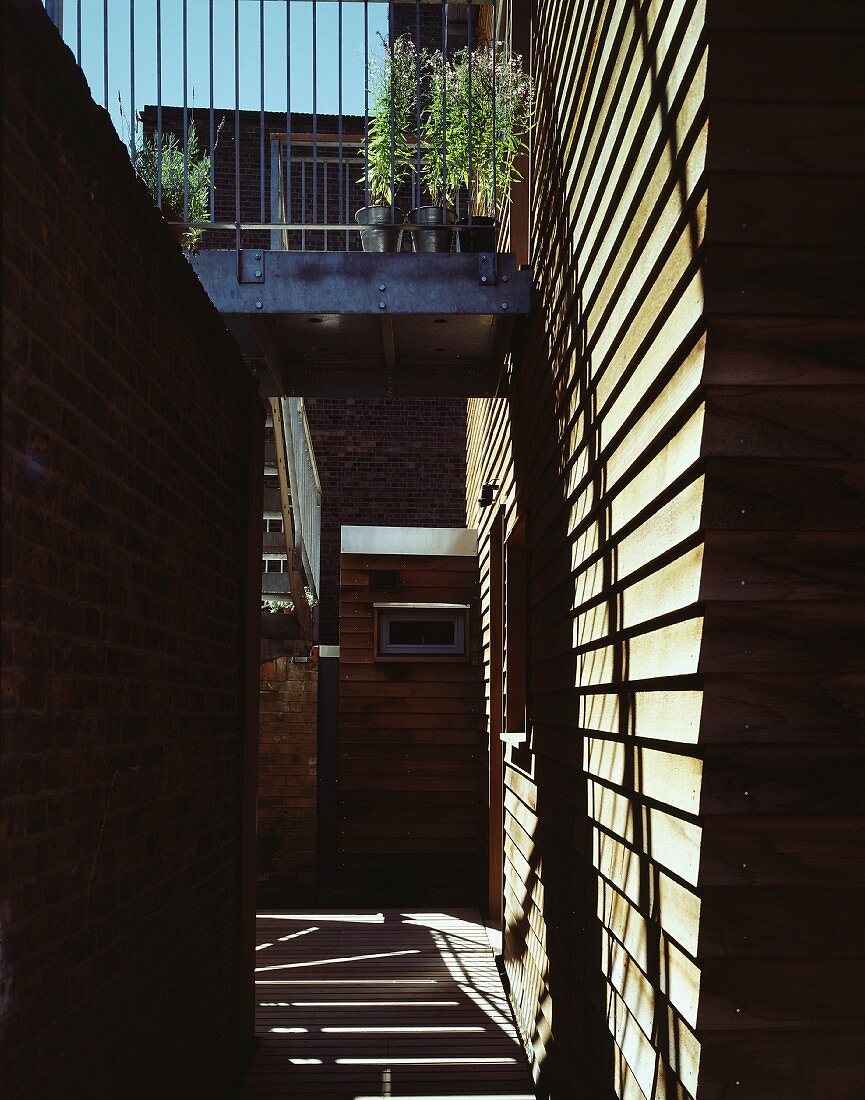 Modernes Wohnhaus mit Holzfassade und Balkon aus Metall