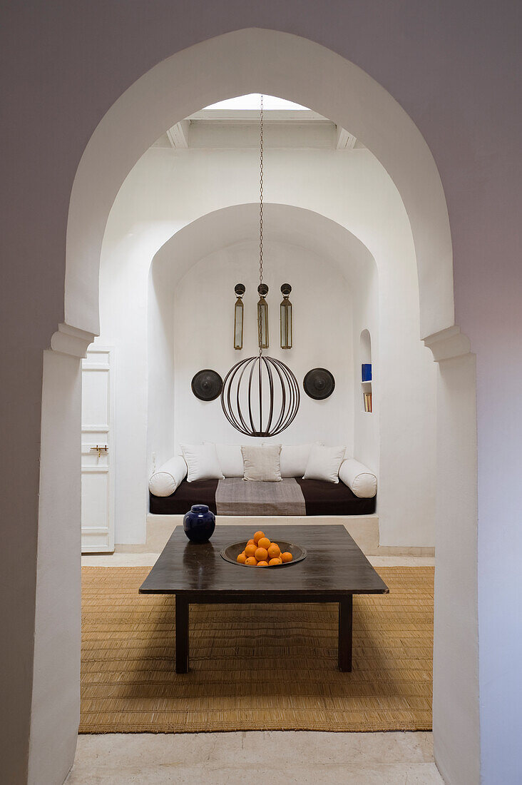 Room with oriental archway, table and seating area