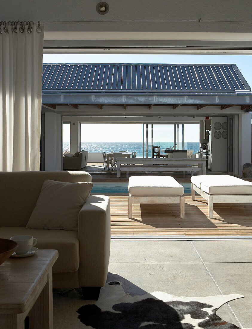 Open-plan living area with pool terrace and sea view