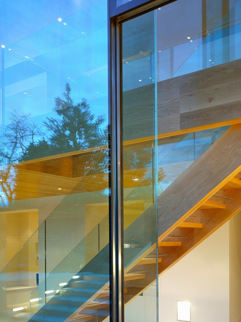 Blick durch Glasfront auf Treppe aus Holz