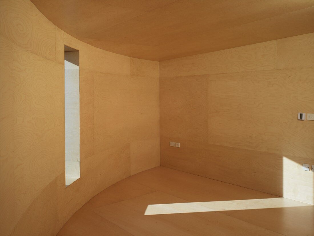 Leerer Raum mit geschwungener Wand und Holzverkleidung an Wand, Decke und Boden
