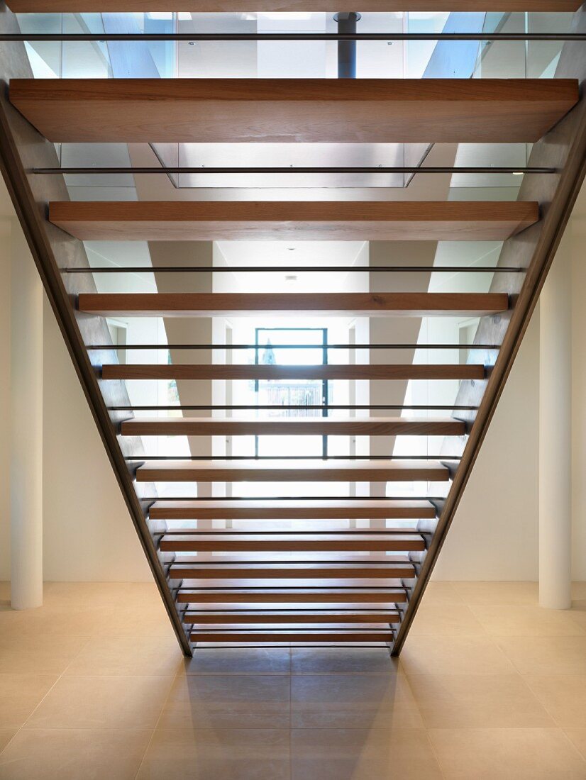Rückansicht einer Treppe mit Holzstufen im modernen Vorraum
