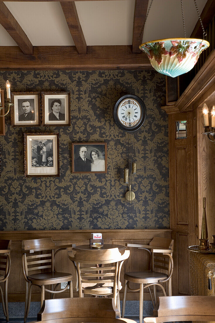 Vintage-style dining room with dark patterned wallpaper and wooden furniture