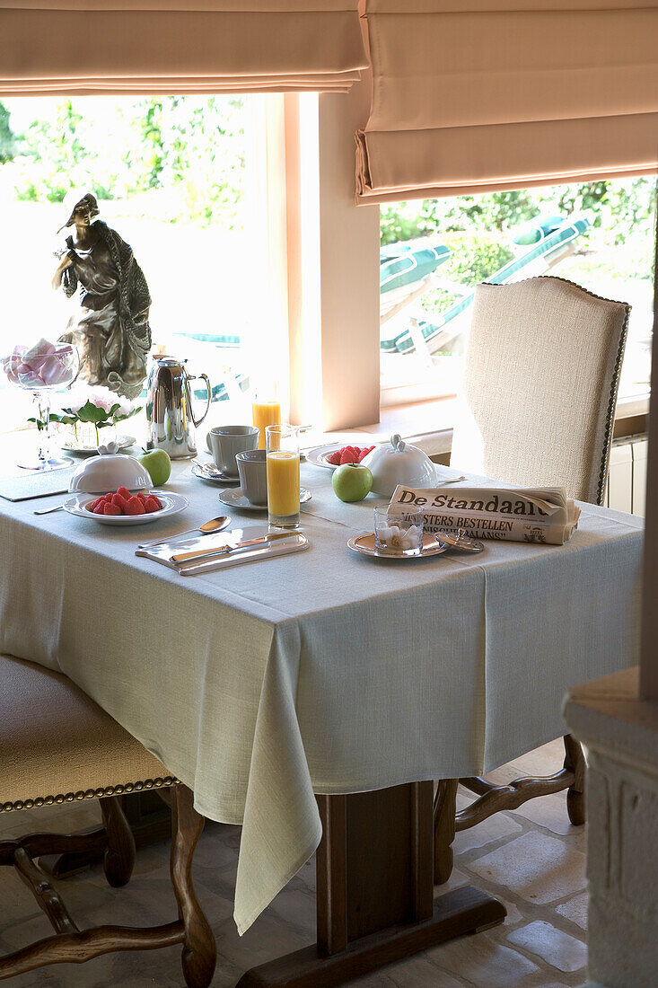 Set breakfast table with fruit and freshly squeezed juice