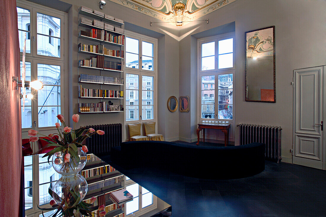 Room with bookshelf, stucco decoration on the ceiling and dark floor