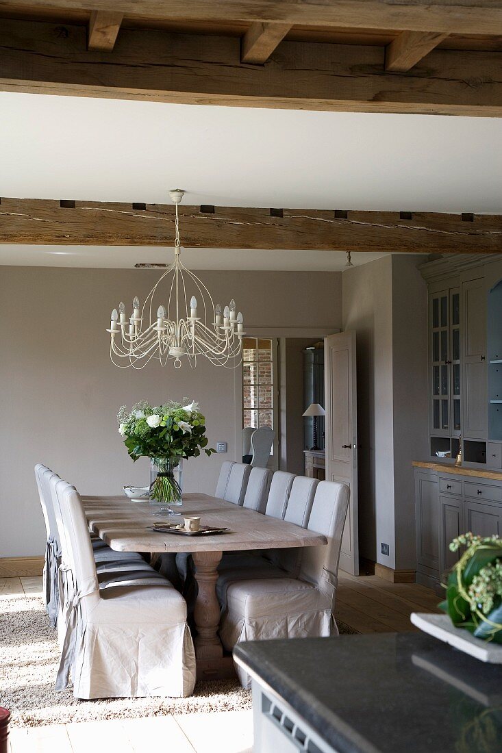 Festive dining table and loose-covered chairs in renovated country house