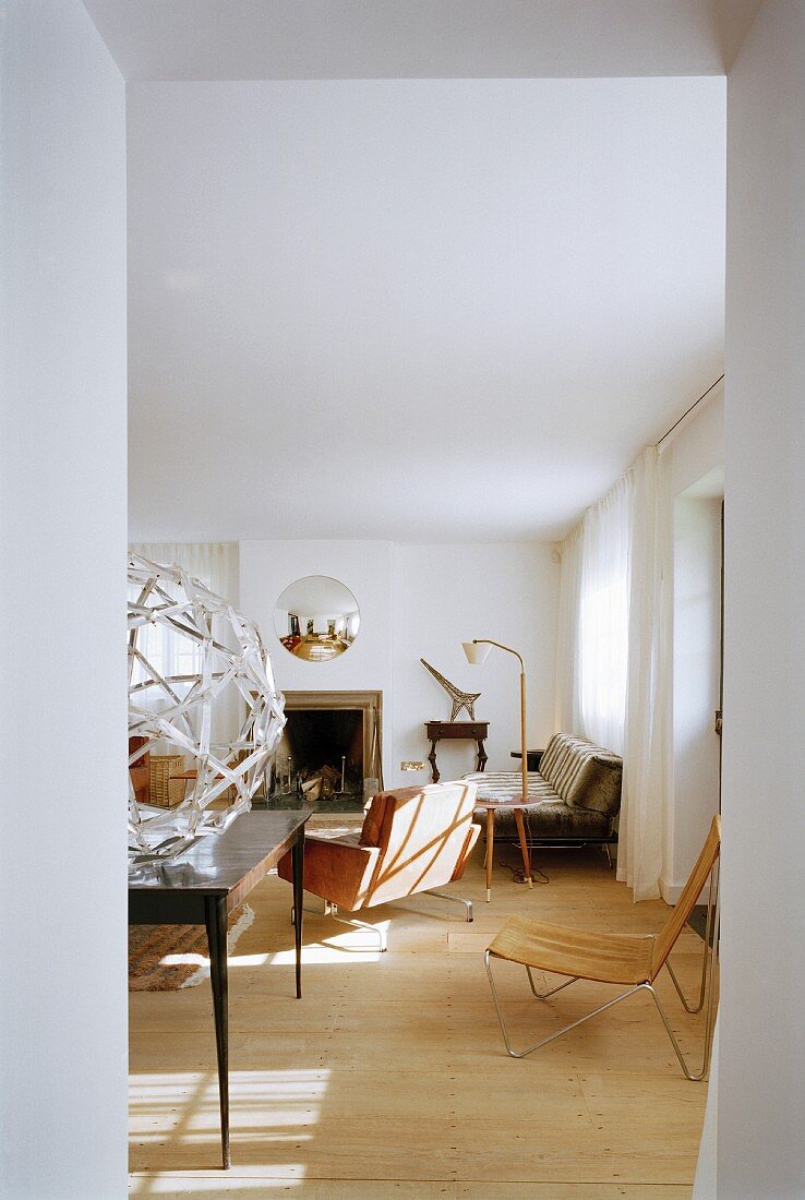 Blick in ein Wohnzimmer mit verschiedenen Sitzmöbeln und Kamin