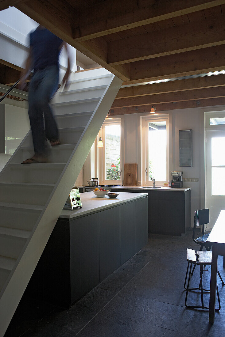 Kitchen with dark cupboards under the stairs