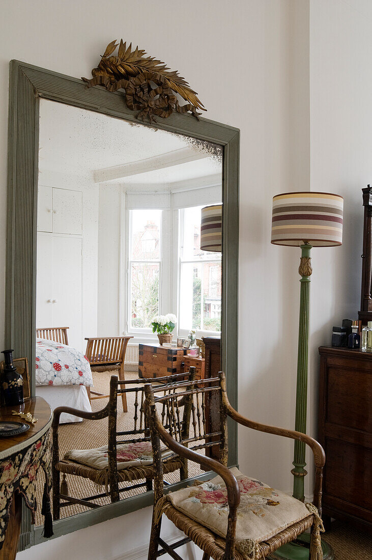 Mirror and wooden chair in a classic living room with natural light