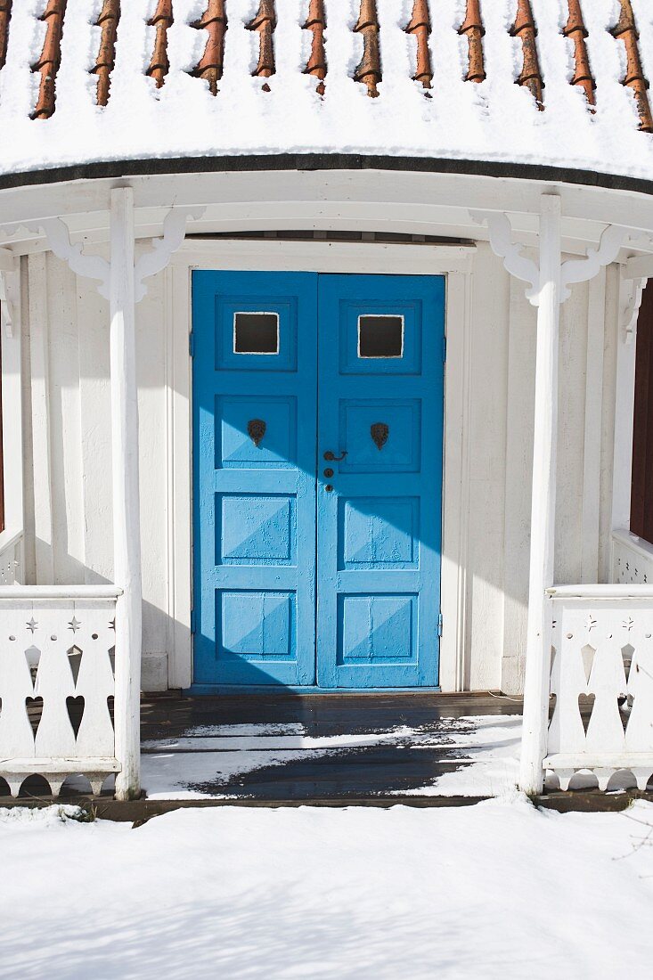 Snowy porch with blue front door