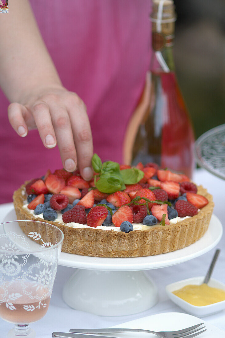 Beerenkuchen mit frischen Basilikumblättern