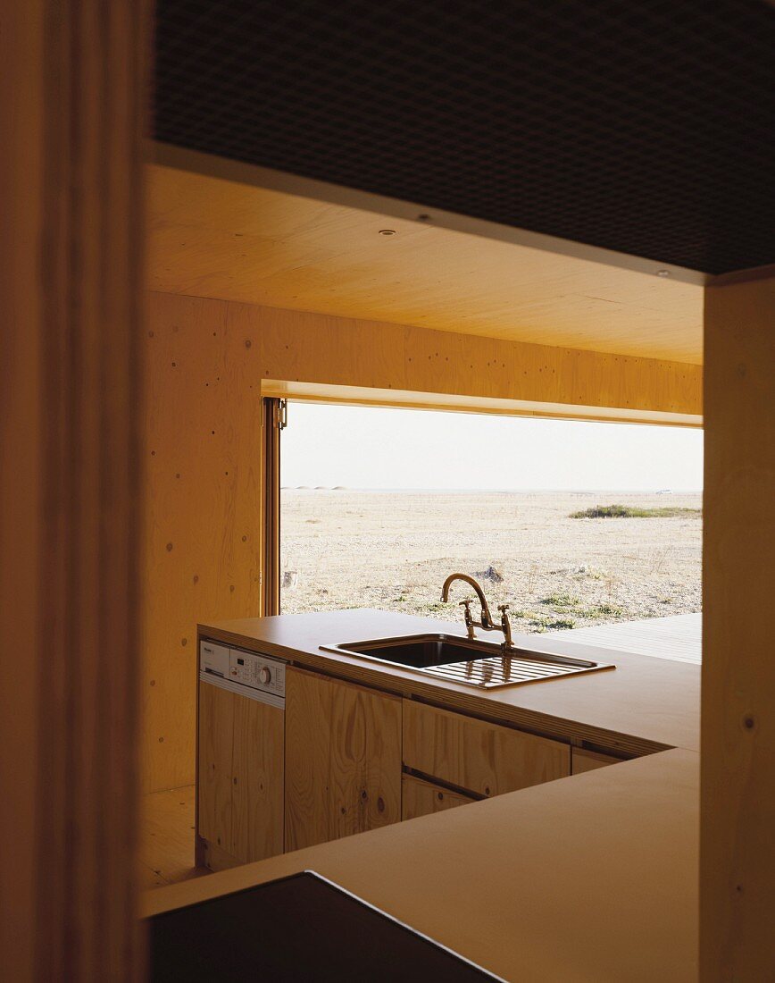 Blick durch offene Tür auf Küchenblock und geöffnetem Terrassenfenster