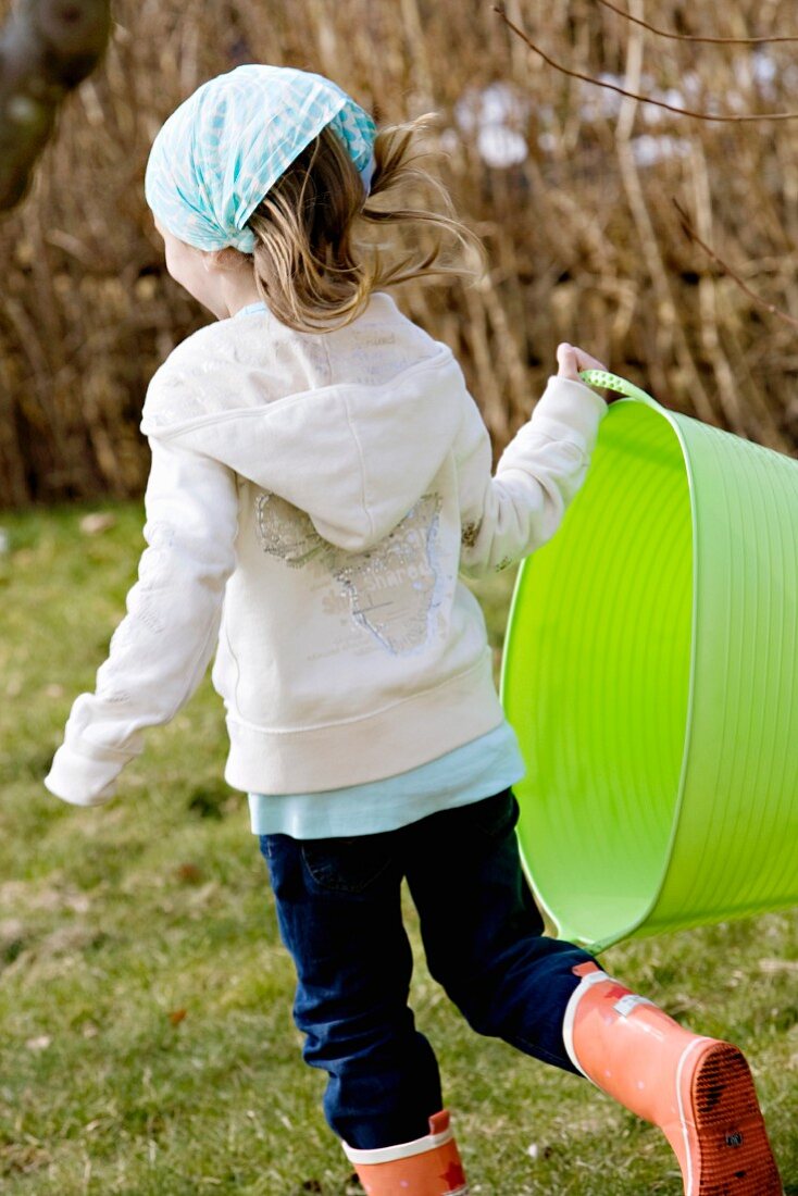 Girl walking in garden holding green basket