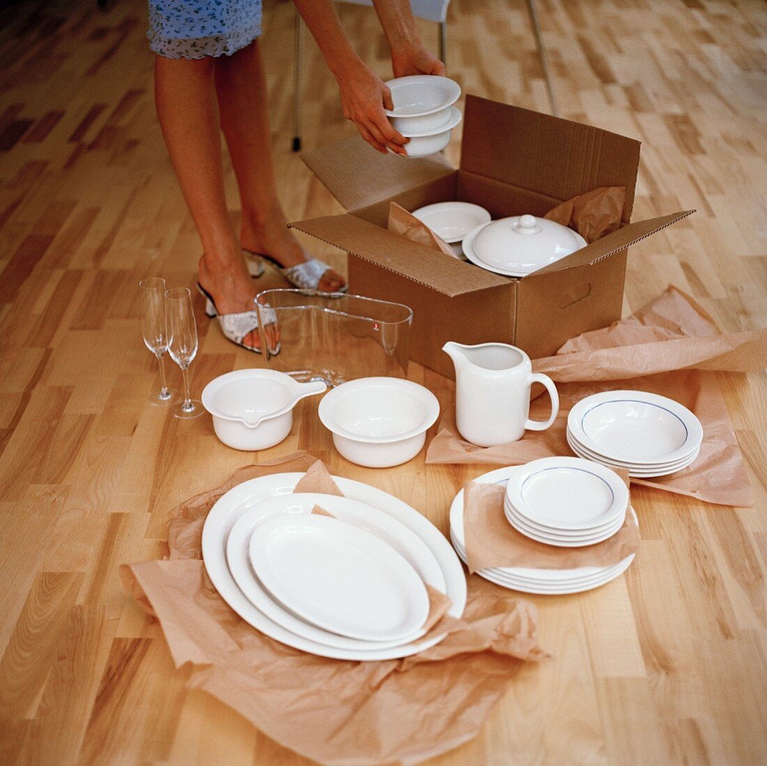 Woman unpacking white porcelain from box