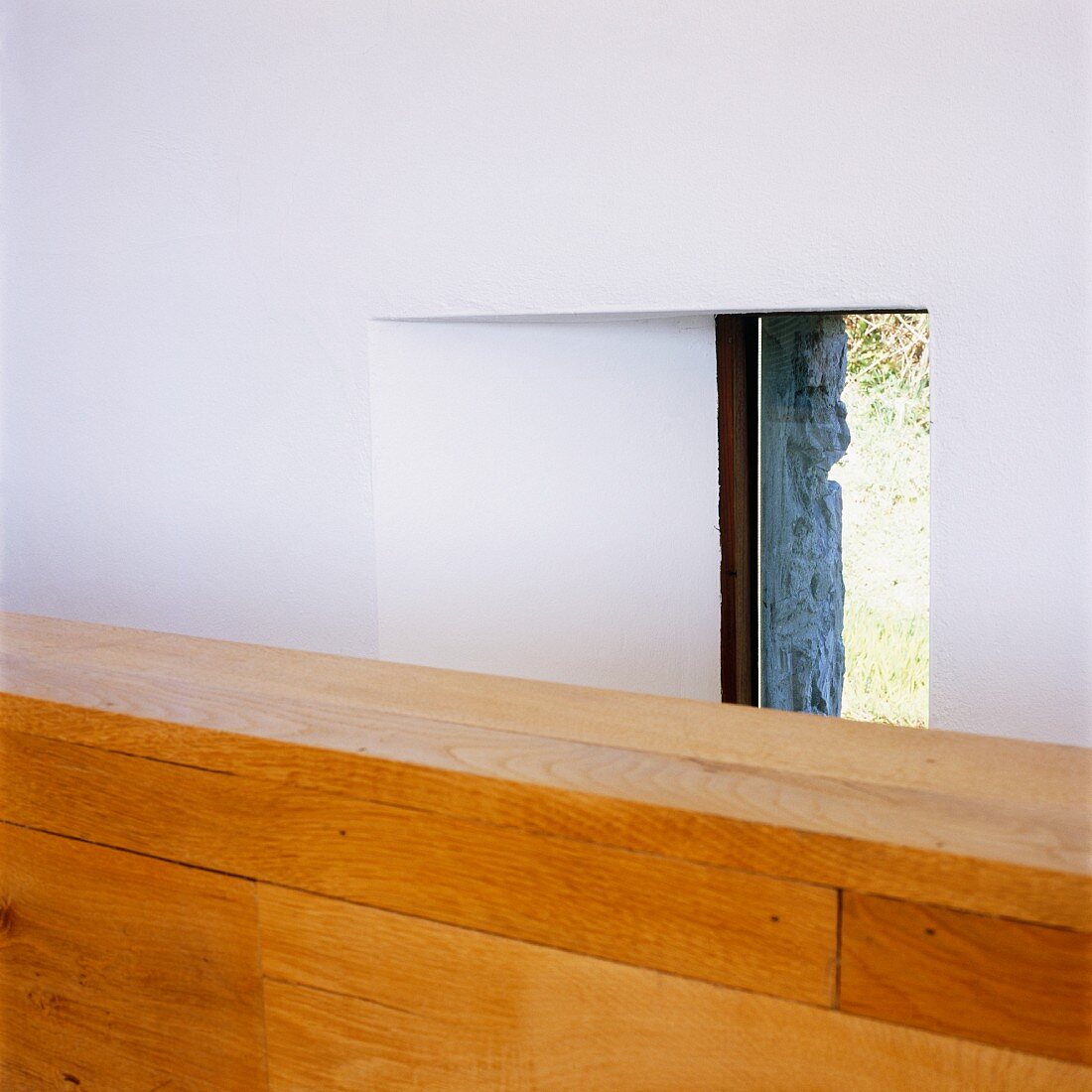 Ausschnitt von einer halbhohen Holzwand vor Fenster