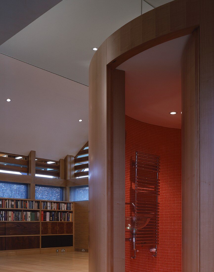 Installation with open door and view of stainless steel towel warmer on wall with red mosaic tiles