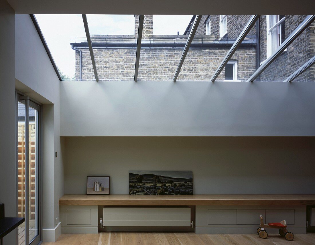 Minimalistischer Wohnraum im modernen Anbau mit Glasdach
