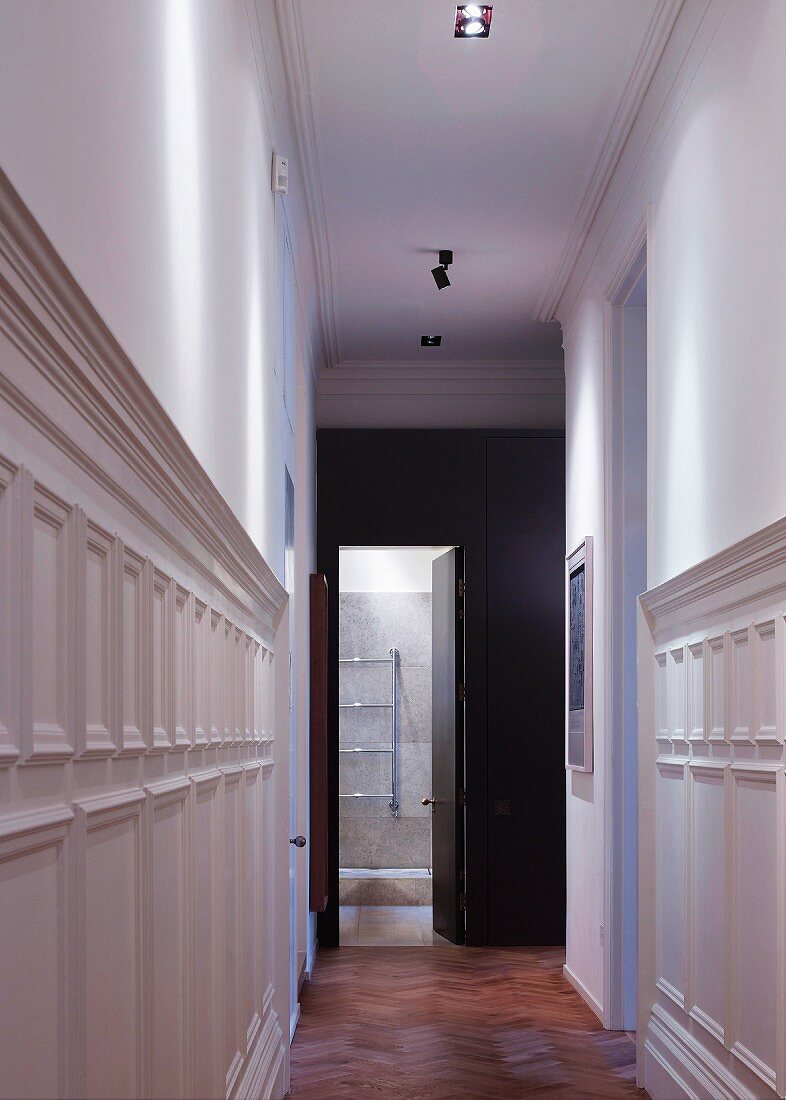 Narrow hallway with white-painted, half-height wood panelling