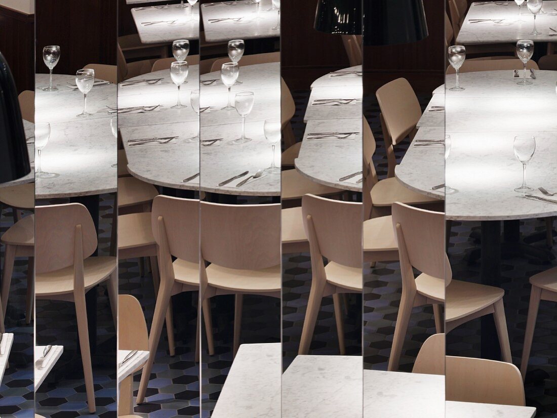 Spiegelungen von Stühlen und Tischen in vertikalen Spiegelpanelen