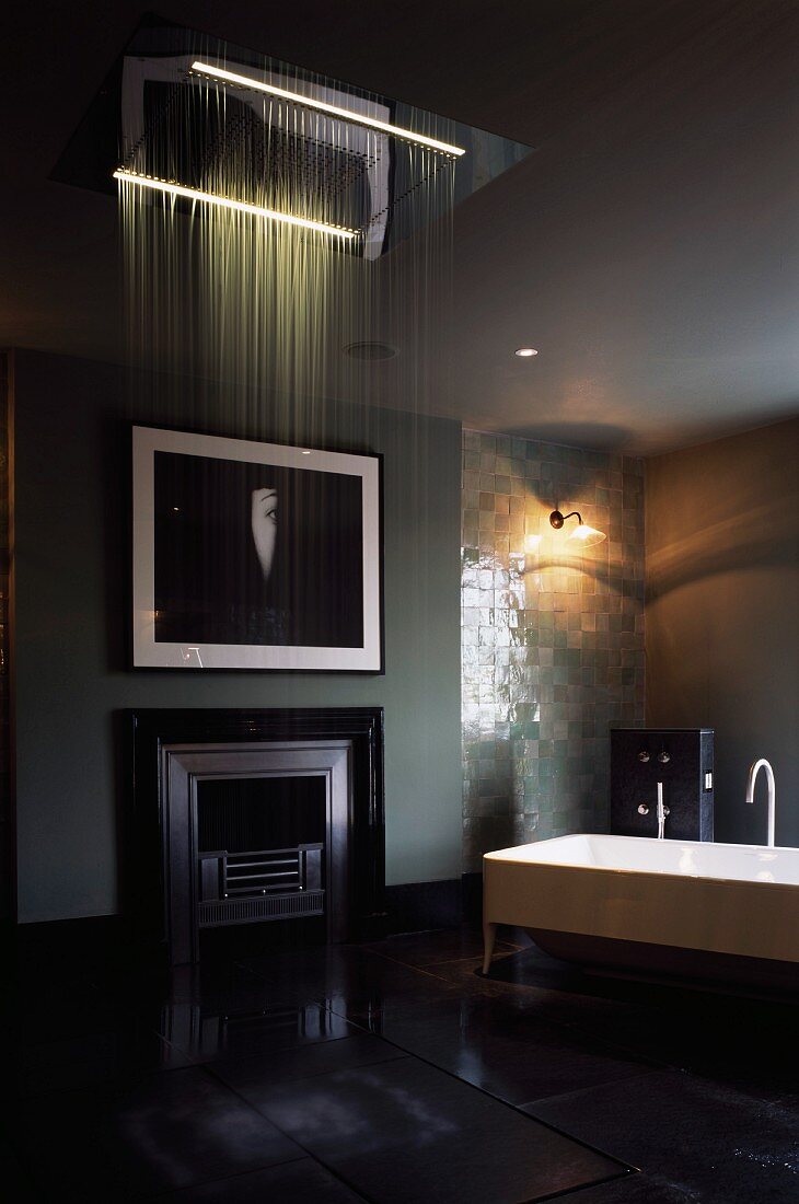 High-ceilinged bathroom with free-standing bathtub and fireplace with dramatic lighting