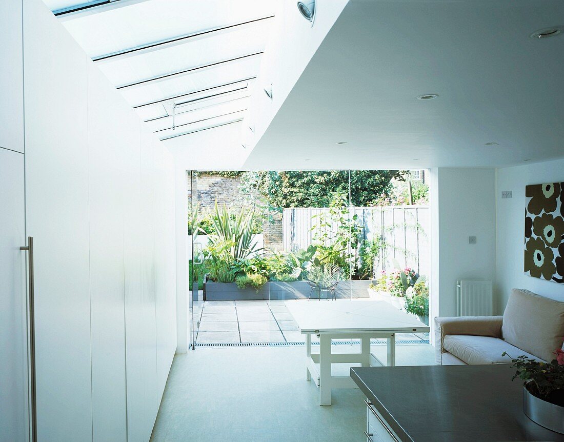 Moderner Wohnraum mit Blick auf bepflanzte Terrasse