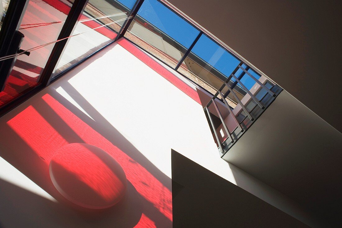 Glasfront mit rotem Schatten und verglastes Dach