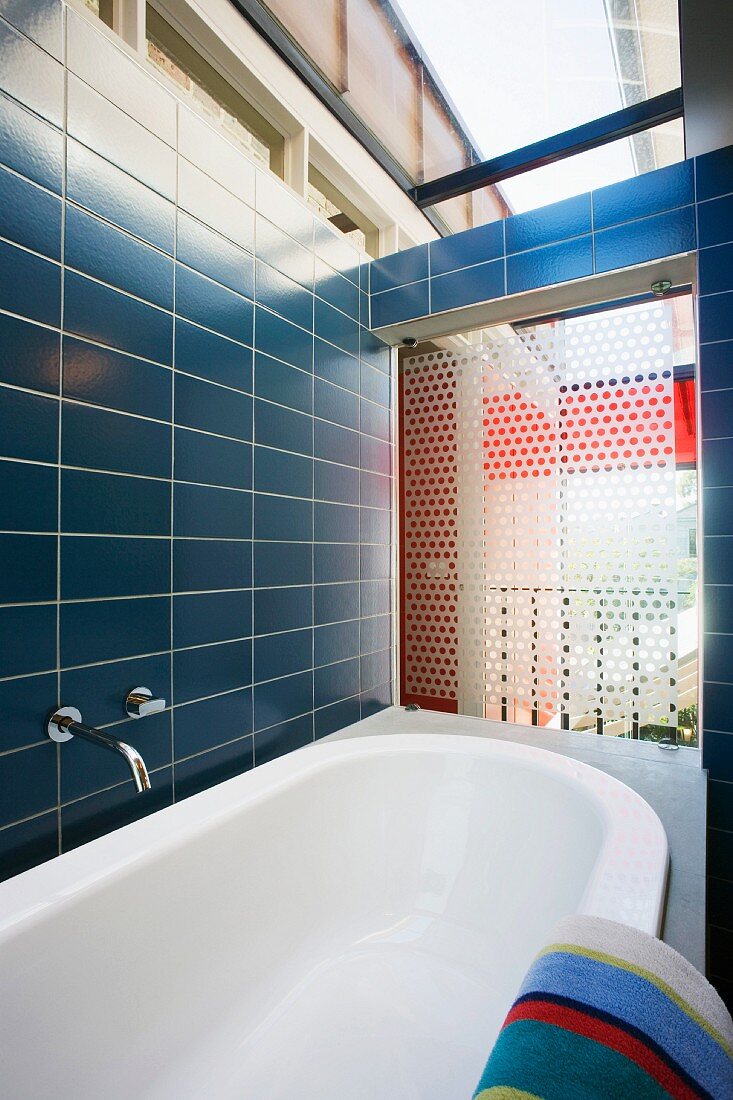 Badezimmer mit blauen Wandfliesen und Oberlicht