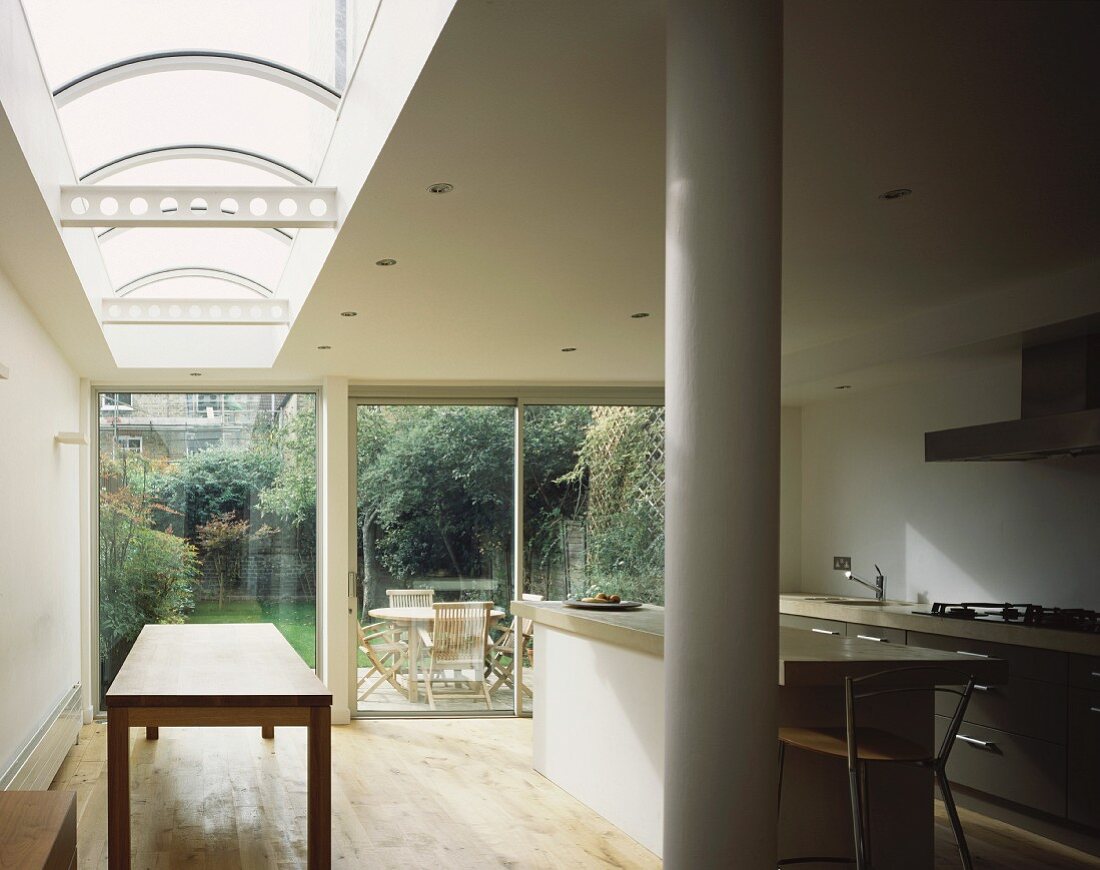 Kitchen with skylight and glass wall leading to terrace