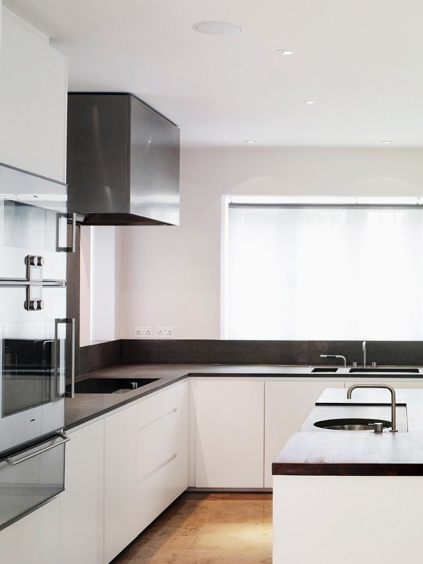 Kitchen island in front of designer fitted kitchen