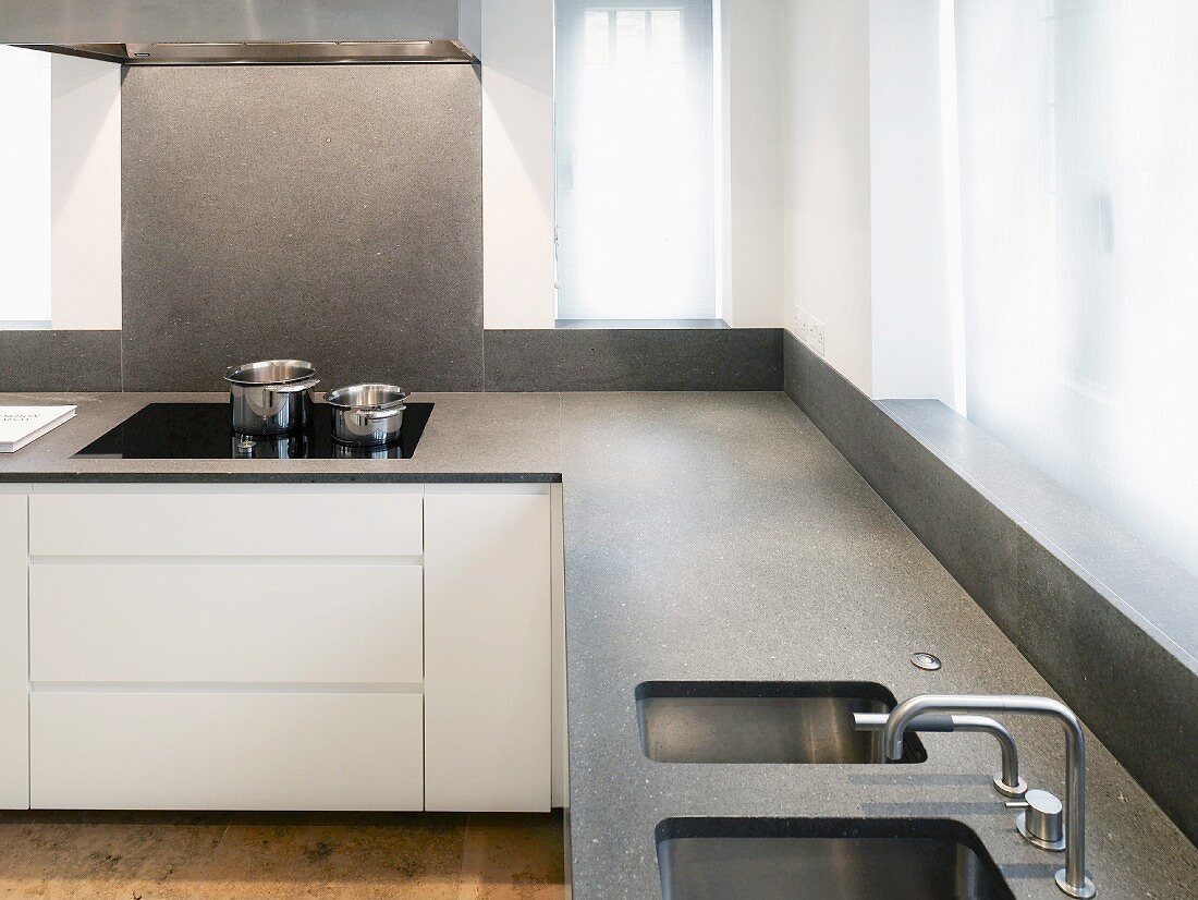 Küchenzeile übereck mit grauer Steinplatte und integrierter Spüle