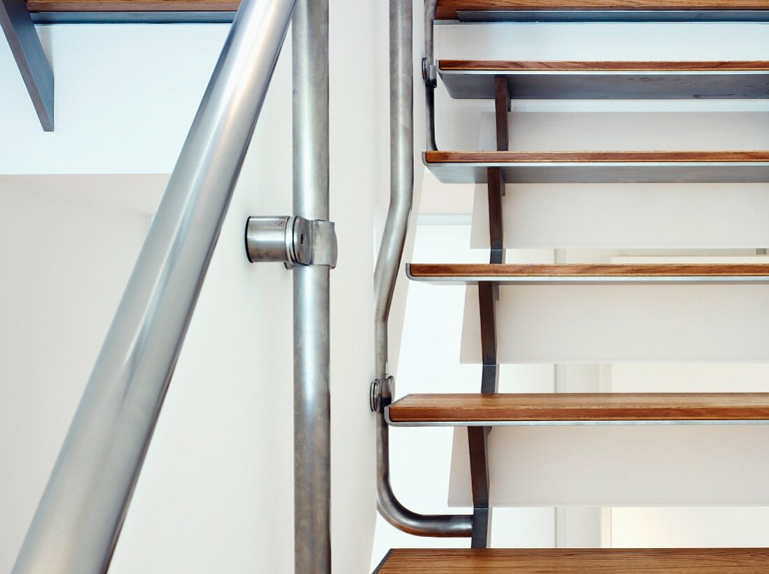 Ausschnitt einer Treppe mit Holzstufen und Geländer aus Edelstahl