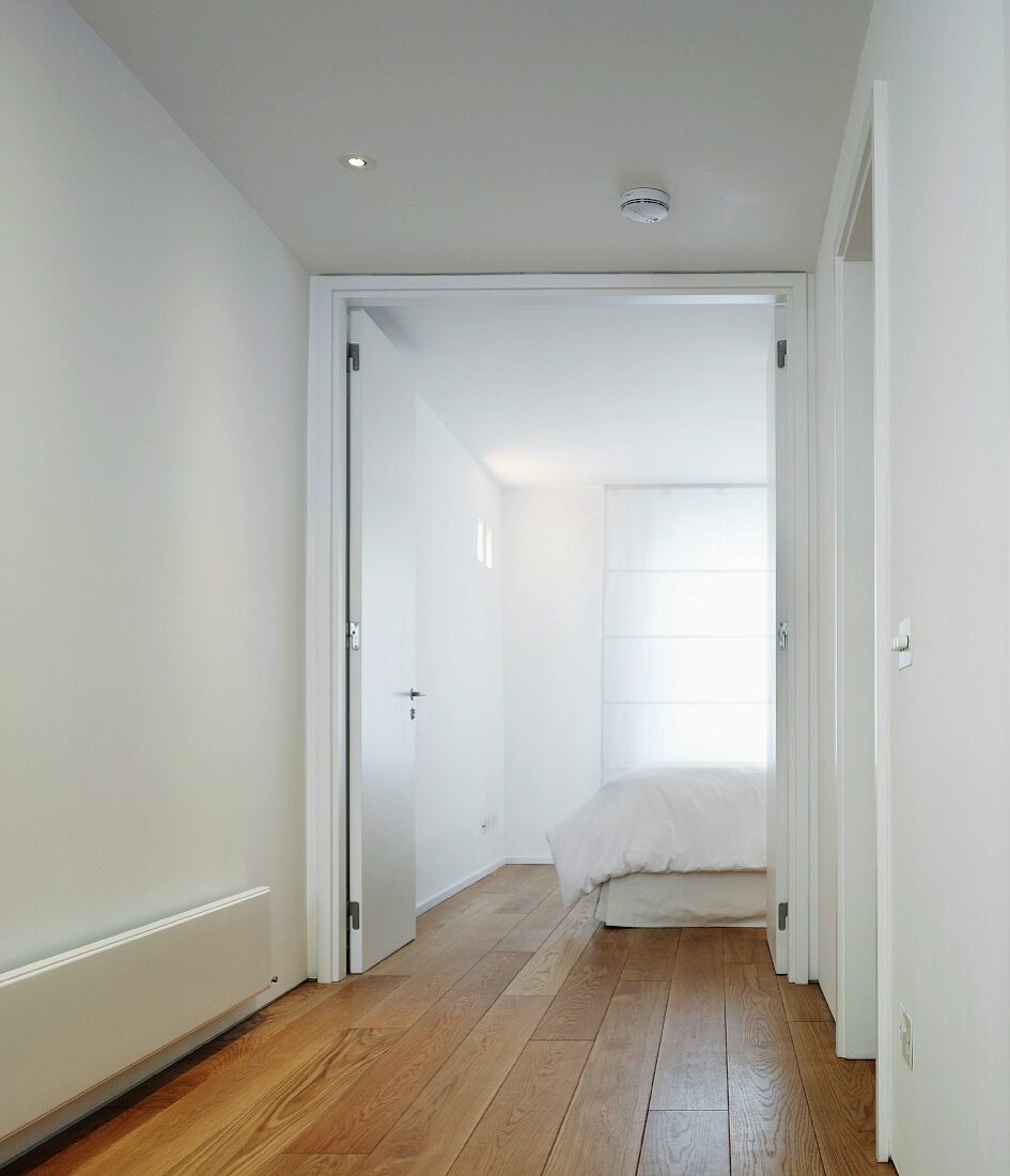 White-painted hallway with open double doors and view of bedroom