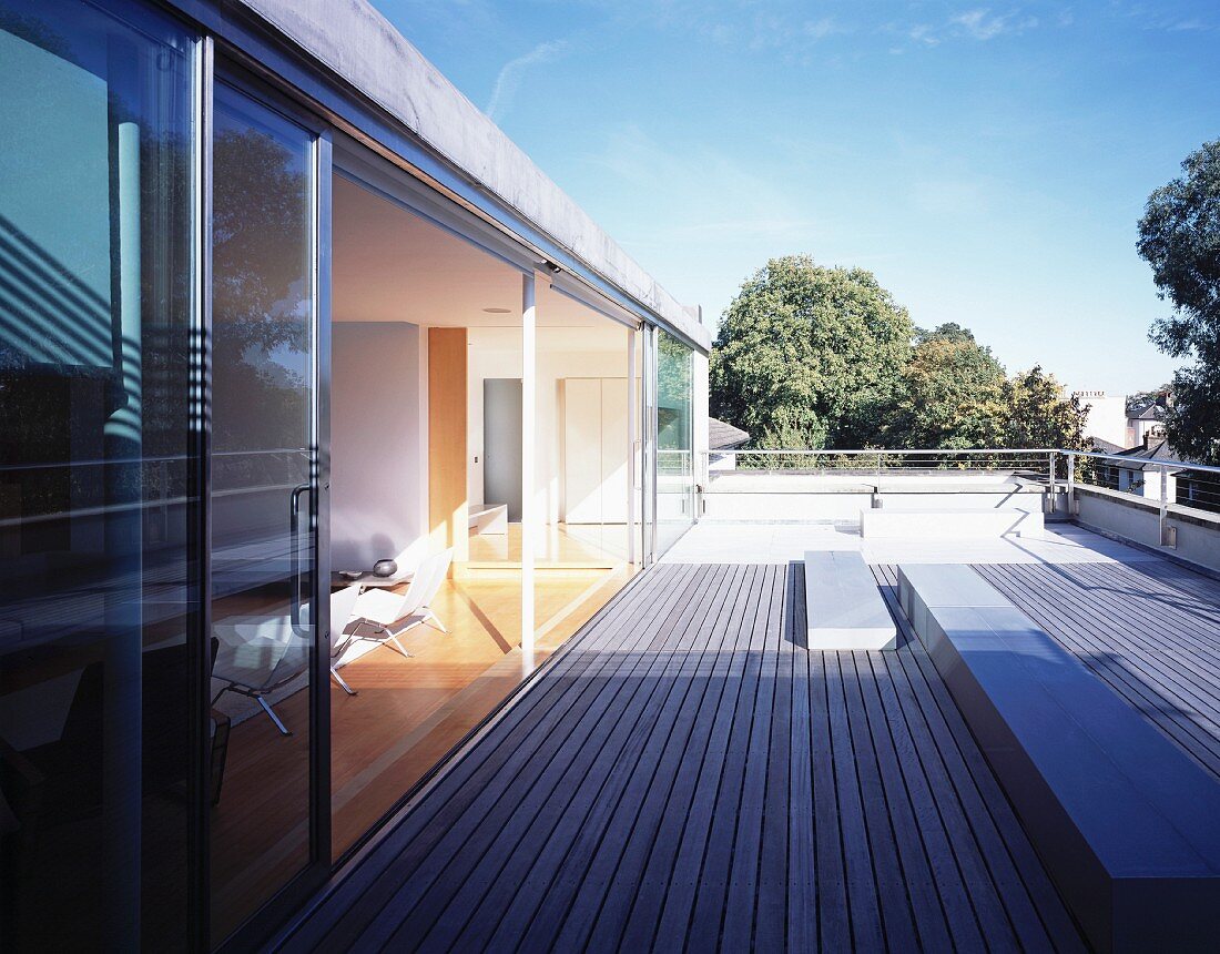 Roof terrace with wooden decking and sliding glass door leading to living room