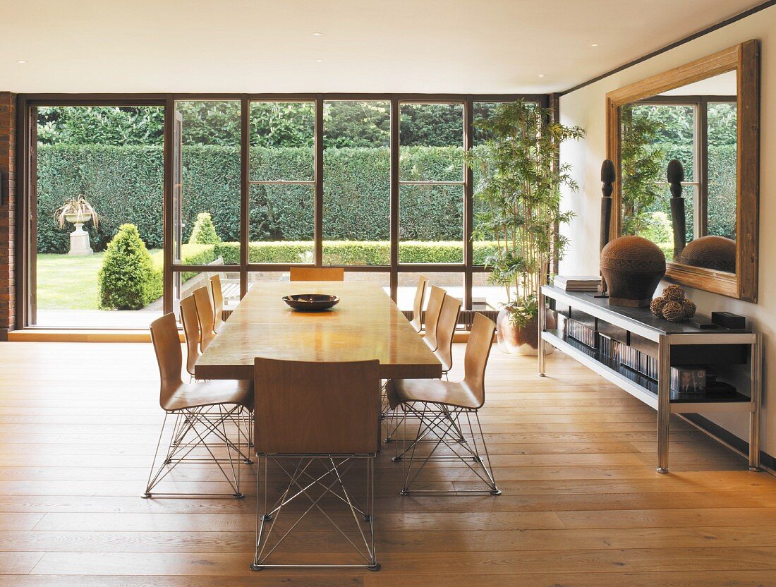 Long dining table and chairs in open-plan room